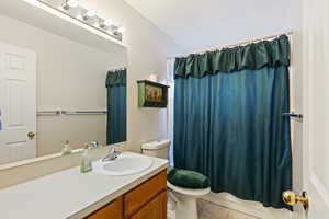 Full bathroom featuring tile patterned floors, shower / tub combo with curtain, vanity, and toilet