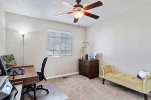 Home office featuring light colored carpet and ceiling fan