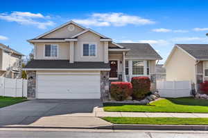 View of front of property featuring a garage and a front yard