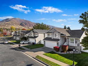 View of front of home featuring a garage, a front yard, and a mountain view