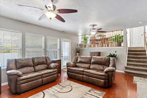 Living room with a wealth of natural light, wood-type flooring, and a textured ceiling