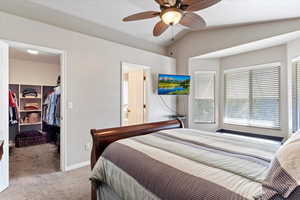 Bedroom featuring vaulted ceiling, light carpet, ceiling fan, a closet, and a spacious closet