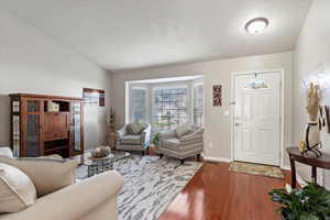 Living room featuring hardwood / wood-style floors and lofted ceiling