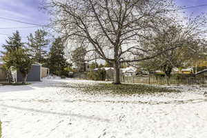 Yard covered in snow with an outbuilding