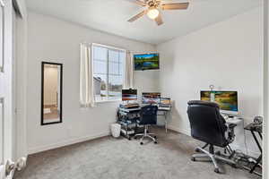 Office area with carpet flooring and ceiling fan