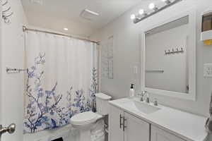 Bathroom featuring a textured ceiling, vanity, toilet, and walk in shower