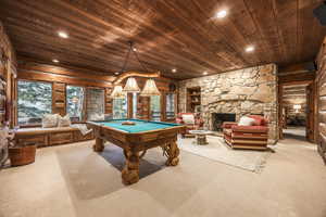 Game room featuring light carpet, pool table, a fireplace, and wood ceiling