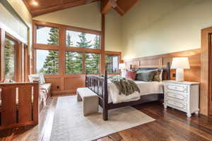 Bedroom featuring beam ceiling, high vaulted ceiling, and dark hardwood / wood-style floors