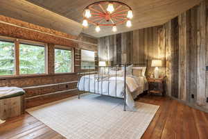 Bedroom with wood-type flooring, wood walls, and wood ceiling