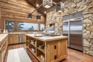 Kitchen featuring wooden ceiling, high vaulted ceiling, tile countertops, appliances with stainless steel finishes, and light wood-type flooring