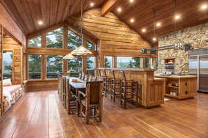 Dining area with wooden ceiling, high vaulted ceiling, and wood-type flooring