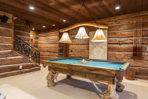 Recreation room with rustic walls, wooden ceiling, billiards, and carpet flooring