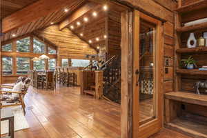 Wine area with vaulted ceiling with beams, hardwood / wood-style floors, and wood ceiling