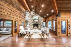 Living room with beamed ceiling, hardwood / wood-style flooring, a fireplace, and wood ceiling