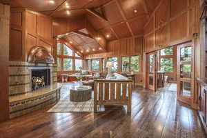 Living room featuring wood ceiling, wood walls, high vaulted ceiling, and wood-type flooring