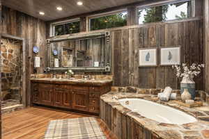 Bathroom with wooden walls, hardwood / wood-style flooring, vanity, a tub, and wood ceiling