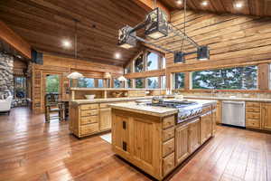 Kitchen with light hardwood / wood-style flooring, wooden ceiling, a center island, decorative light fixtures, and stainless steel appliances