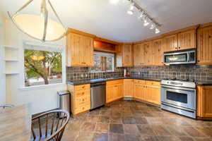 Kitchen with appliances with stainless steel finishes, backsplash, and sink