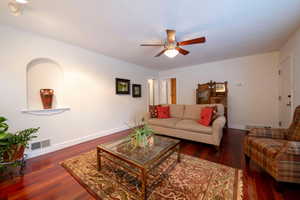 Living room featuring dark hardwood / wood-style flooring and ceiling fan