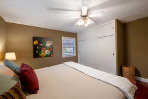 Bedroom featuring a closet, ceiling fan, and a textured ceiling