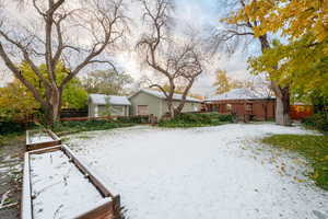 Yard covered in snow featuring an outdoor structure