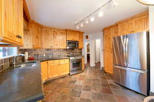 Kitchen with backsplash, stainless steel appliances, and sink