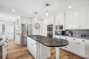 Kitchen with white cabinetry, appliances with stainless steel finishes, and light hardwood / wood-style floors