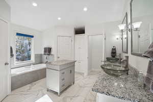 Bathroom featuring vanity and a relaxing tiled tub