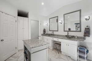 Bathroom featuring vanity and lofted ceiling