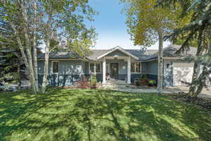 View of front facade featuring a front lawn and a garage