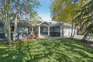 View of front facade featuring a garage and a front lawn