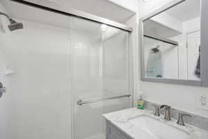 Bathroom featuring vanity and a shower with shower door