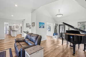 Living room with light hardwood / wood-style flooring and lofted ceiling