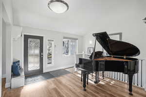 Foyer entrance with lofted ceiling and hardwood / wood-style flooring