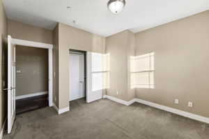 Unfurnished bedroom featuring a closet and carpet floors