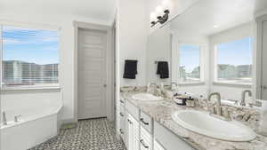 Bathroom featuring vanity, a tub, and tile patterned floors