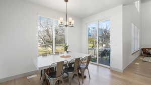 Dining space featuring light hardwood / wood-style flooring, a wealth of natural light, and a notable chandelier