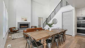 Dining room with a high ceiling and light hardwood / wood-style floors