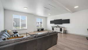 Living room with light hardwood / wood-style flooring, beam ceiling, and a textured ceiling