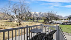 Wooden deck featuring a mountain view, a yard, and a storage shed