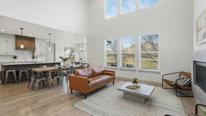 Living room featuring a chandelier, a high ceiling, and light hardwood / wood-style floors