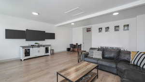 Living room with beamed ceiling and light hardwood / wood-style floors