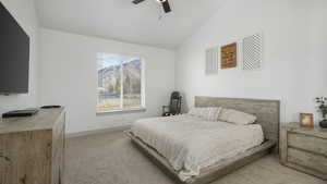 Bedroom featuring light colored carpet, ceiling fan, and lofted ceiling