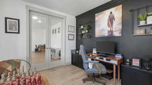 Home office featuring french doors and light hardwood / wood-style flooring