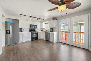 Kitchen featuring white cabinetry, french doors, black appliances, and dark hardwood / wood-style floors