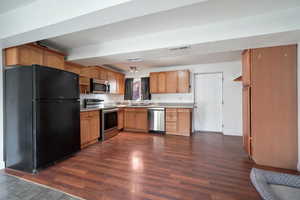 Kitchen with sink, appliances with stainless steel finishes, and dark wood-type flooring