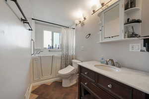 Full bathroom featuring tile patterned flooring, vanity, toilet, and shower / bath combo with shower curtain