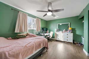 Bedroom featuring ceiling fan, hardwood / wood-style floors, and a textured ceiling