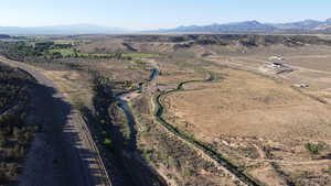 Aerial view of property and surrounding area with a mountainous background and rural landscape