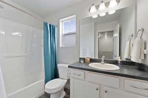 Full upstairs bathroom featuring vanity, toilet, vinyl flooring, and shower / bathtub combination with curtain